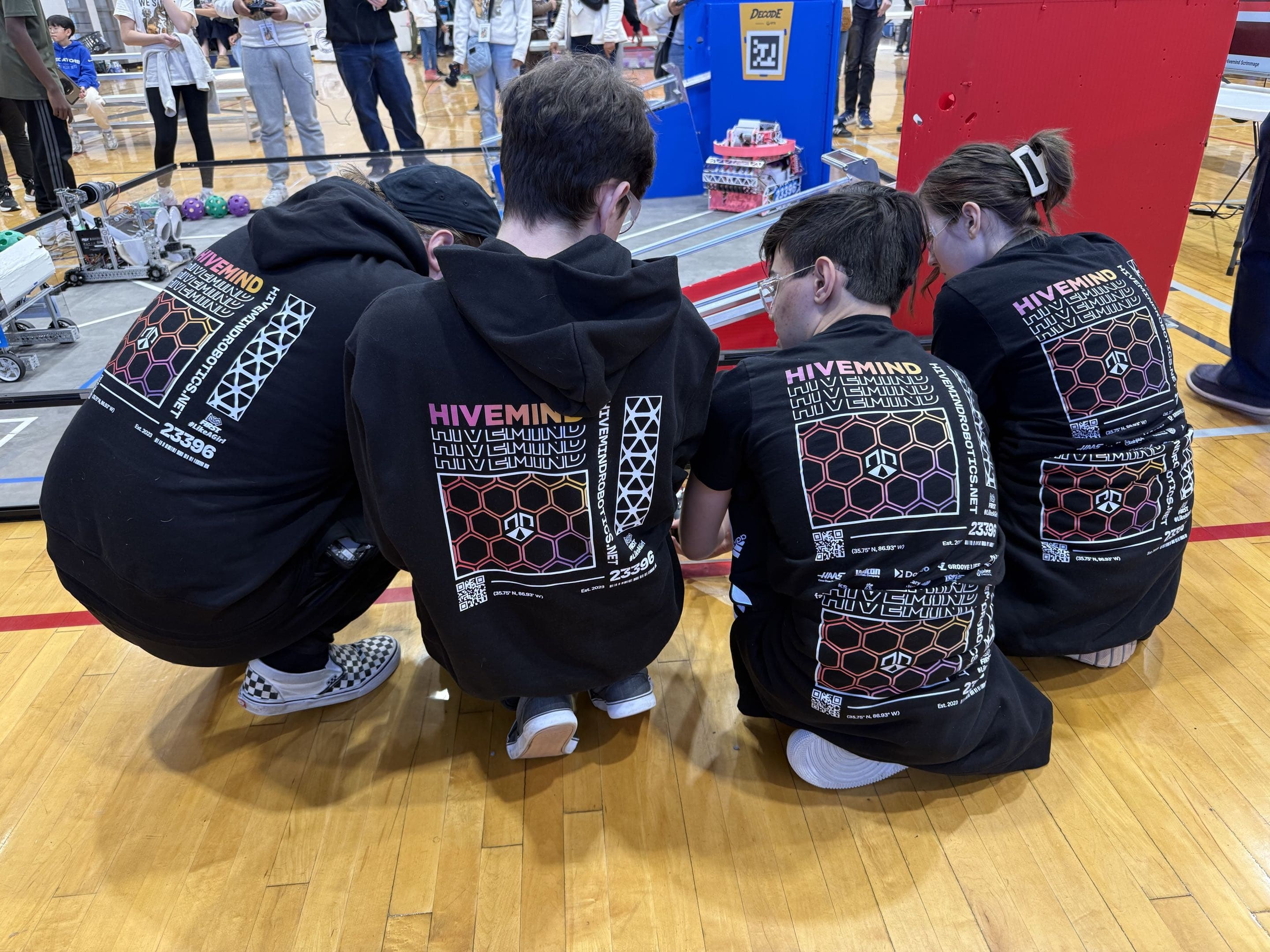 Hivemind students working on the robot at a scrimmage